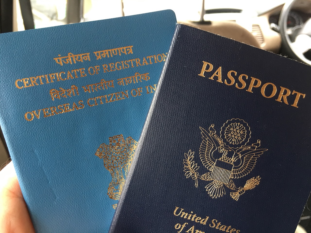 A pair of booklets, one a US passport and one an Indian OCI booklet