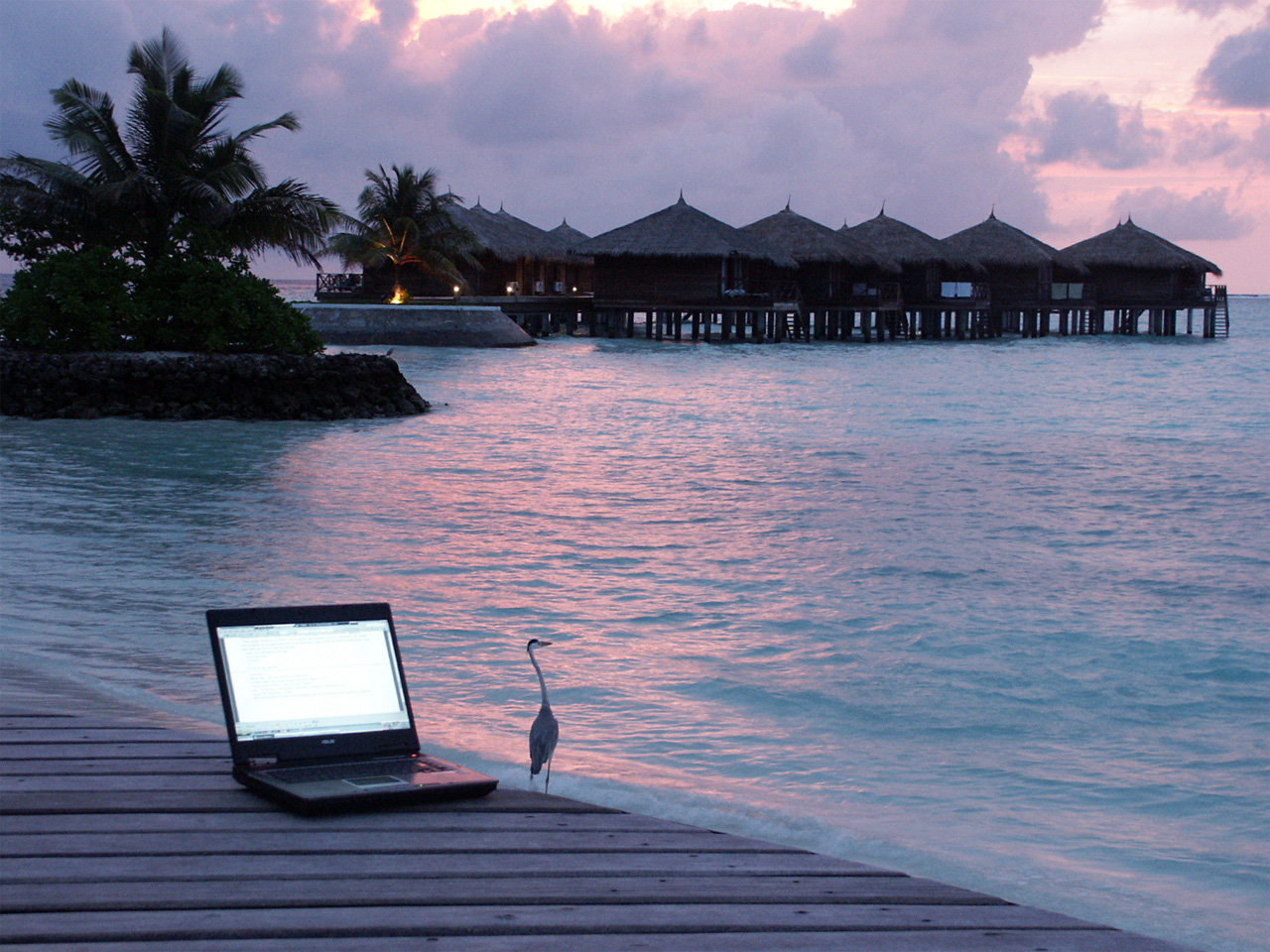 Image of a laptop on a pier by the water